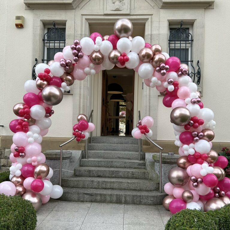 Arche de ballons rose, blanc et or rose à l’entrée d’une maison pour un anniversaire