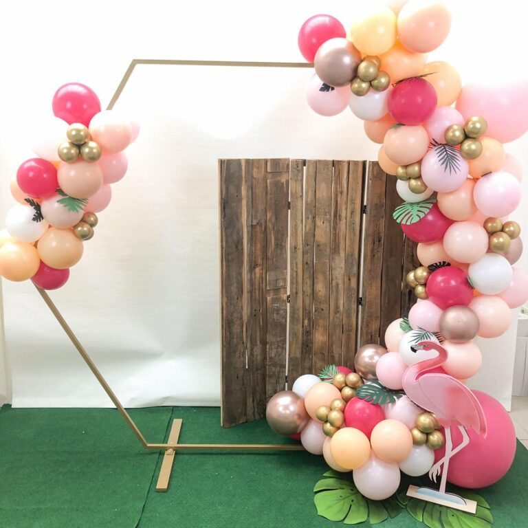 Arche hexagonale en ballons rose, pêche et or avec flamant rose, décor de fête tropicale