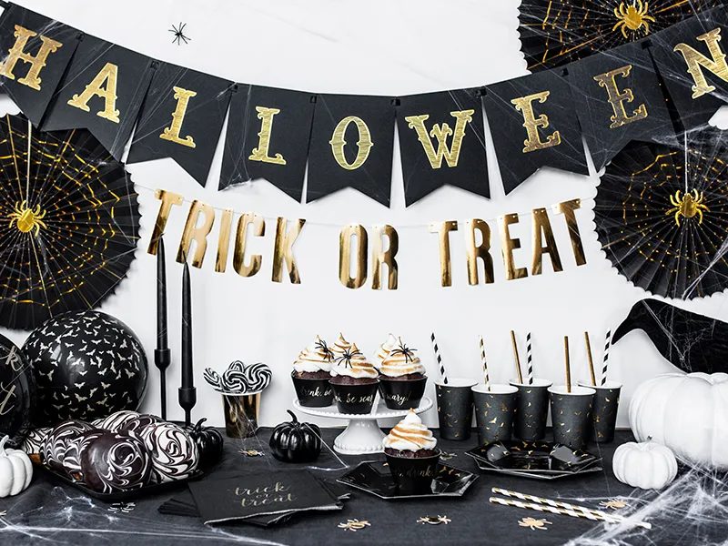 Buffet noir et or avec guirlandes HALLOWEEN et TRICK OR TREAT, cupcakes, gobelets et toiles d'araignée