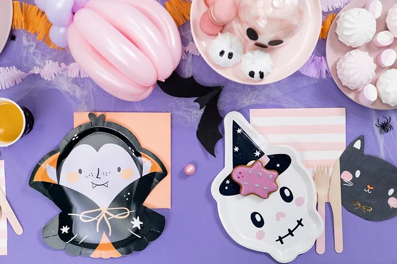 Table d'Halloween pour enfants : assiettes vampire et fantôme rigolos sur nappe violette, meringues fantômes