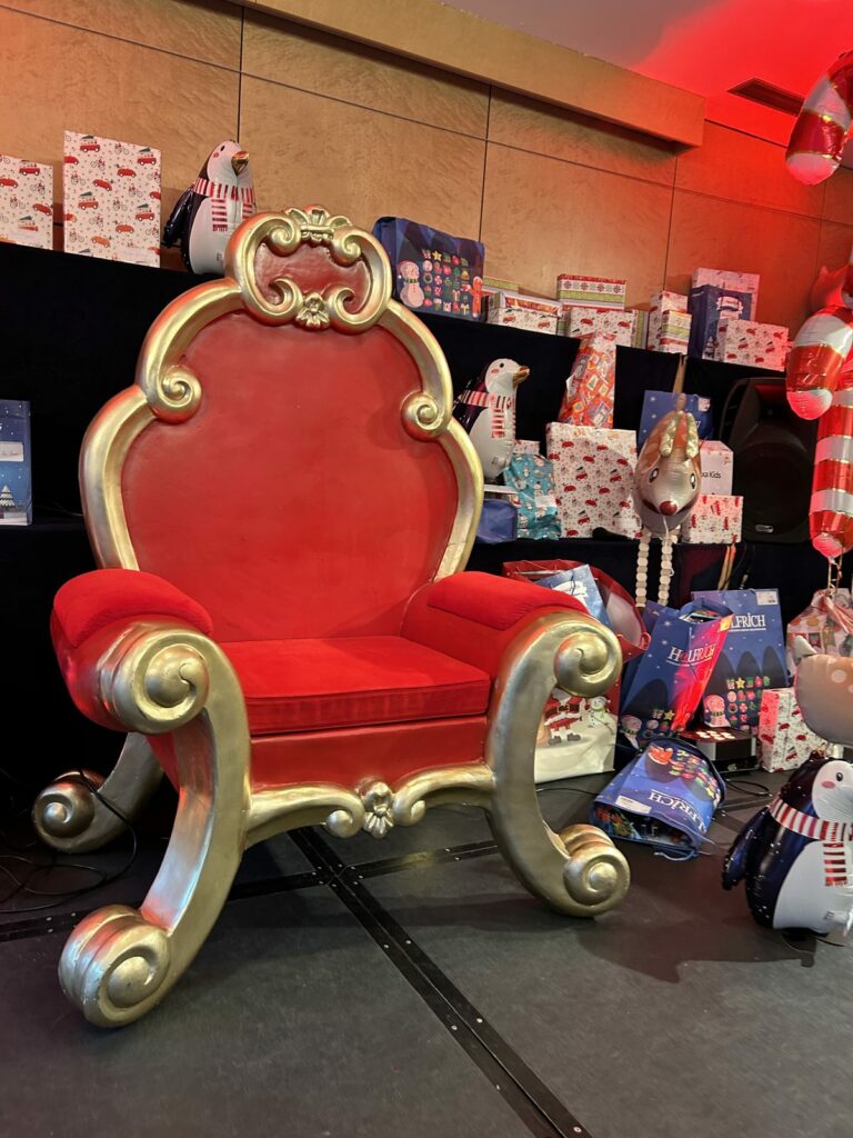 Trône de Saint-Nicolas rouge et doré au cœur du décor de fête