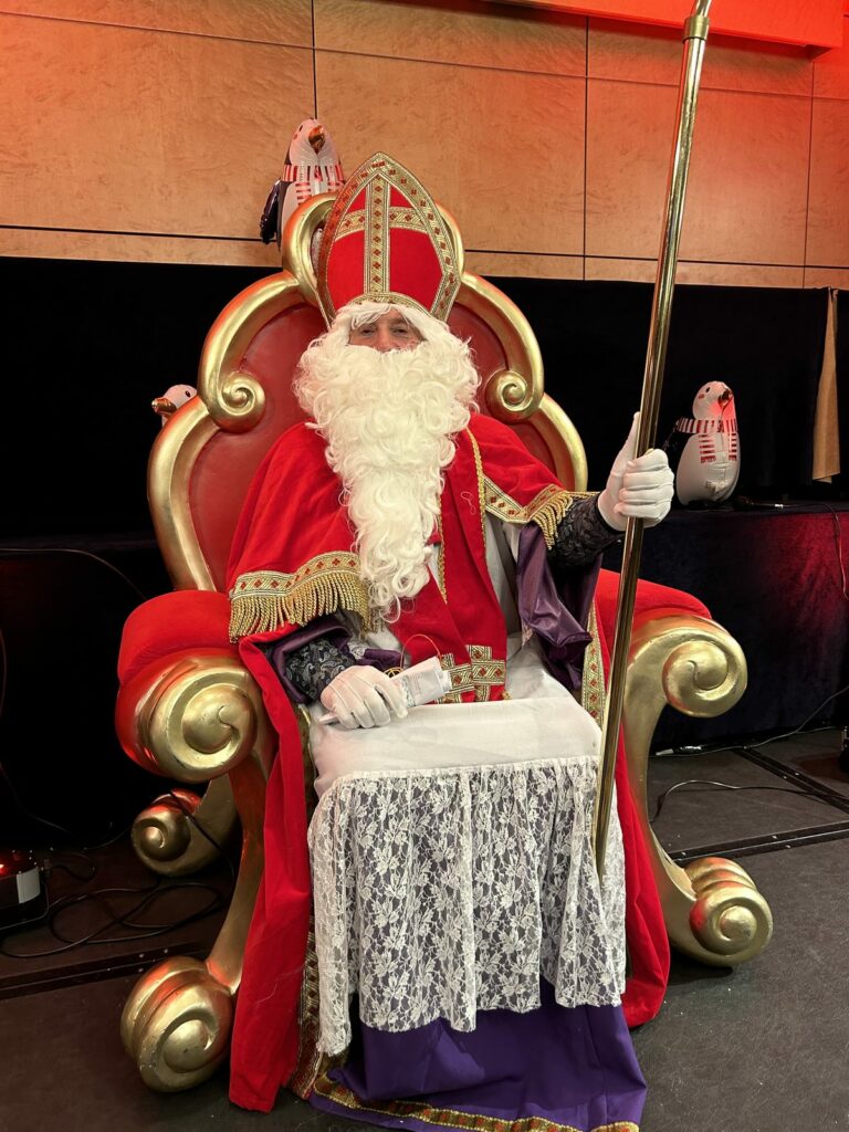 Visite de Saint-Nicolas : le saint assis sur son trône rouge et doré